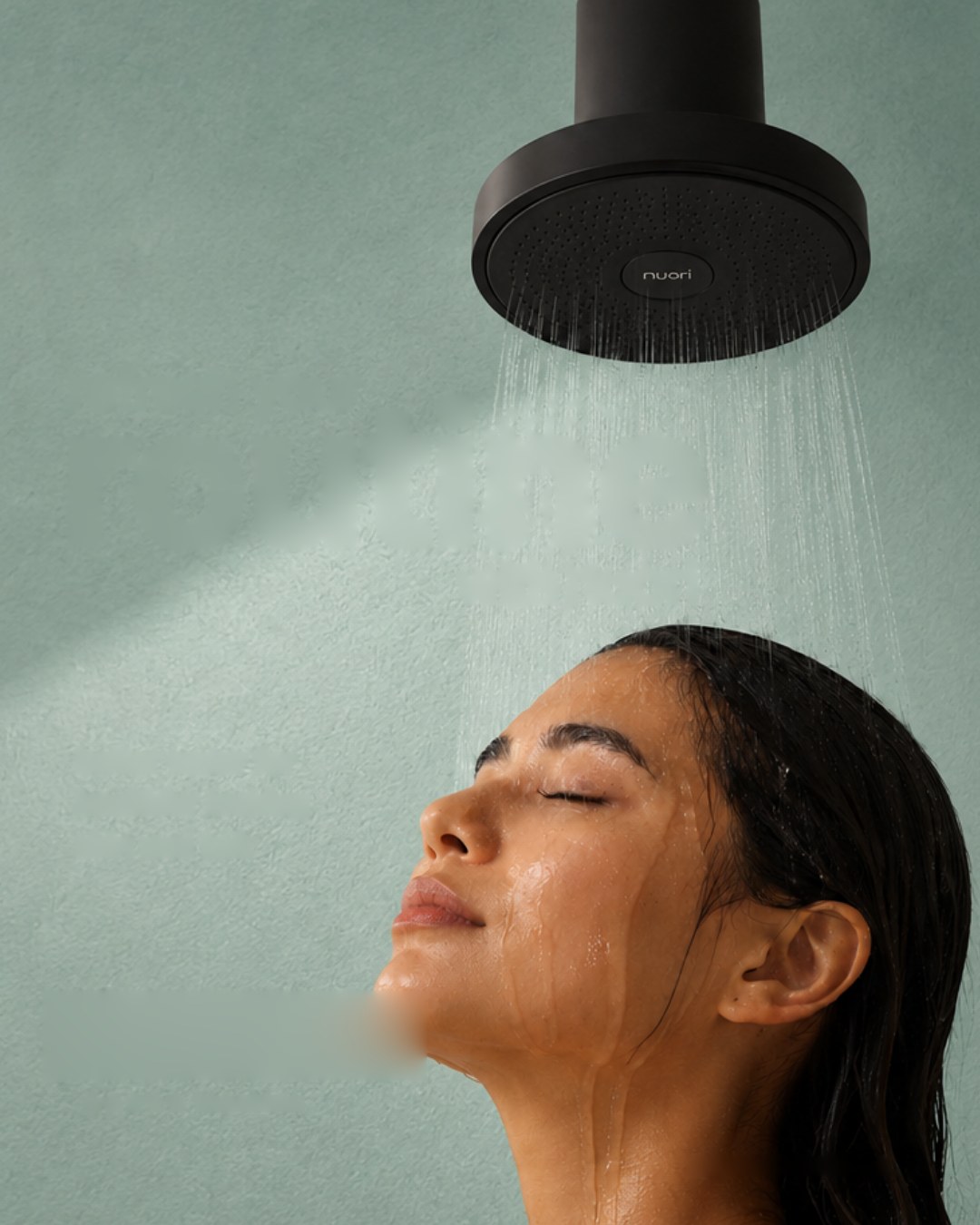 Woman with eyes closed under the matte black Nuori showerhead