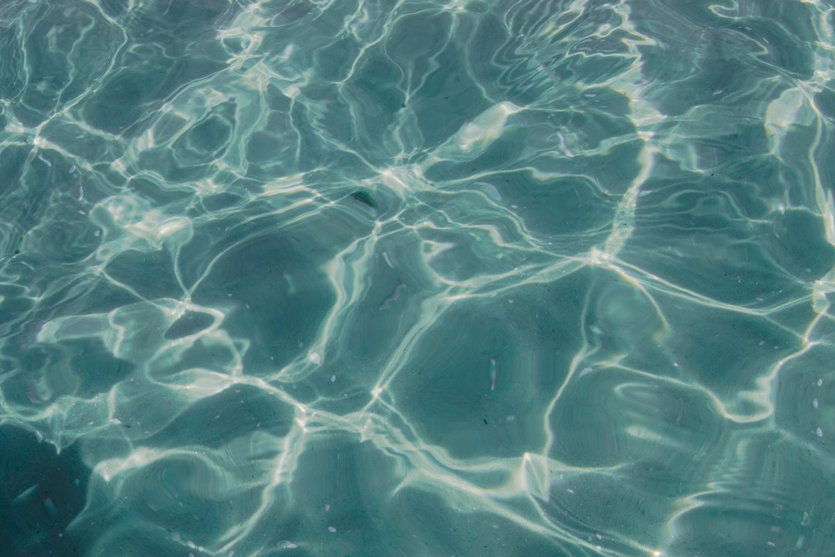 Sunlight rippling through clear teal water